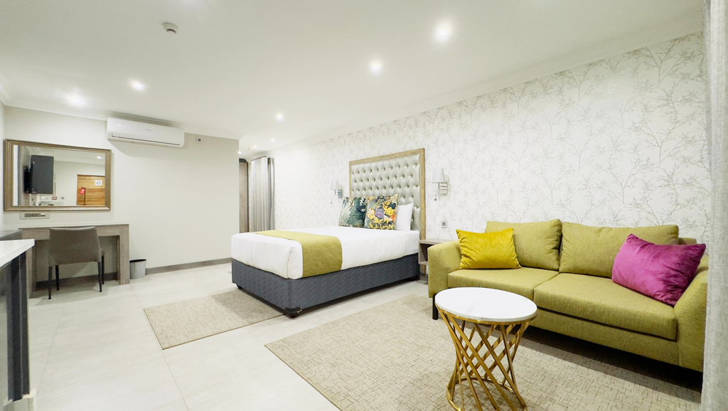 Spacious Guest house room with a bed, couch and a coffee table